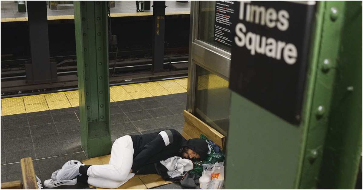 নিউ ইয়র্ক সিটির টাইমস স্কয়ার স্টেশনে শোয়া এক গৃহহীন ব্যক্তি। ছবি: রয়টার্স